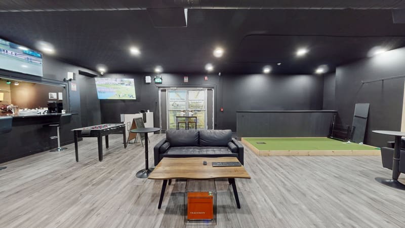 Club X Indoor Golf — wide lounge view with simulator bay, bar, putting area, and seating, set for private events