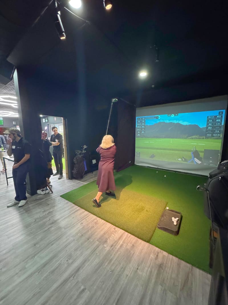 A Club X student mid-swing in Bay 1 with TrackMan live data on the simulator screen, Aurora, Ontario